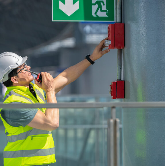 Engineer,Wearing,Safety,Unifrom,And,Helmet,Under,Checking,Fire,Alarm